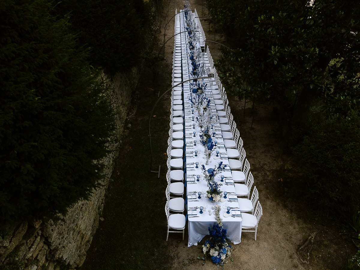 Matrimonio da favola al castello Canalis. Dettaglio del bellissimo tavolo imperiale con lampadari a goccia, fiori, tovaglioli e bicchieri blu. Foto ripresa dal drone.