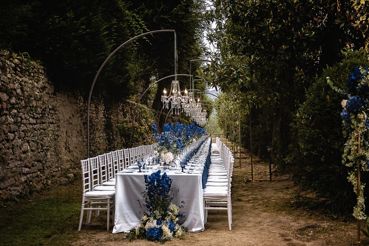 Matrimonio da favola al castello Canalis. Dettaglio del bellissimo tavolo imperiale con lampadari a goccia, fiori, tovaglioli e bicchieri blu.
