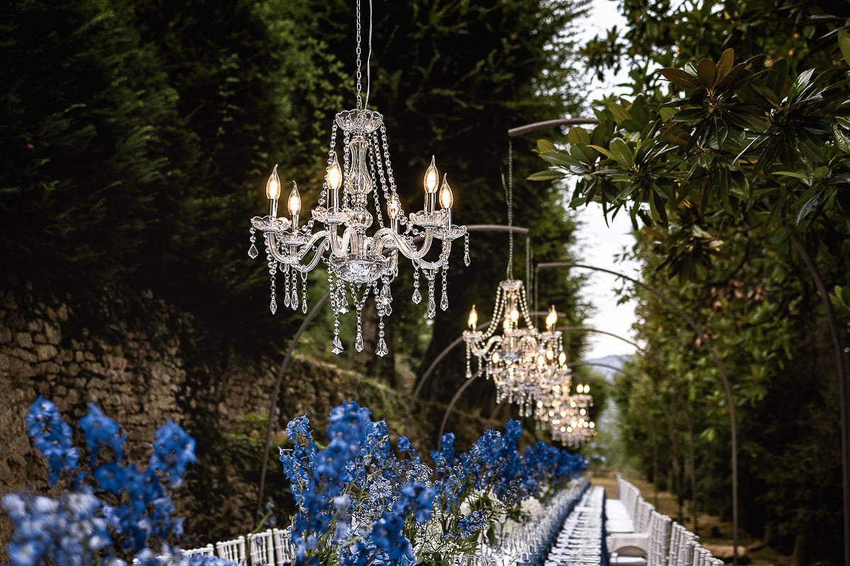 Matrimonio da favola al castello Canalis. Dettaglio del bellissimo tavolo imperiale con lampadari a goccia, fiori, tovaglioli e bicchieri blu.