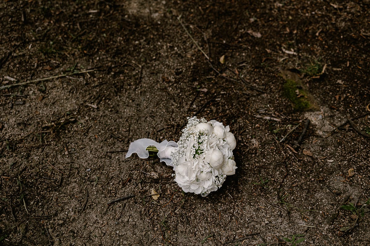 Matrimonio da favola al castello Canalis. Bouquet di peonie bianche posato sul terreno