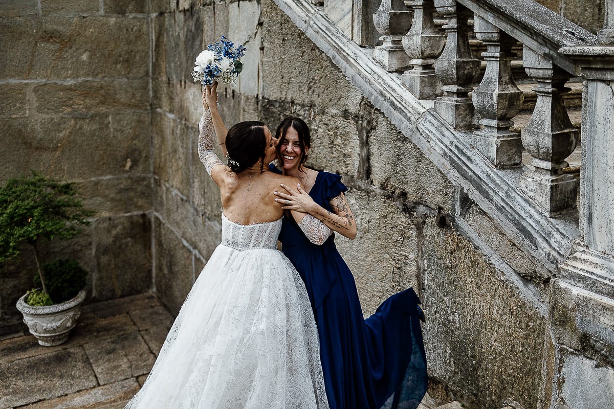 Matrimonio da favola al castello Canalis. Aperitivo. Lancio del bouquet. sposa abbraccia la ragazza che ha preso il bouquet.