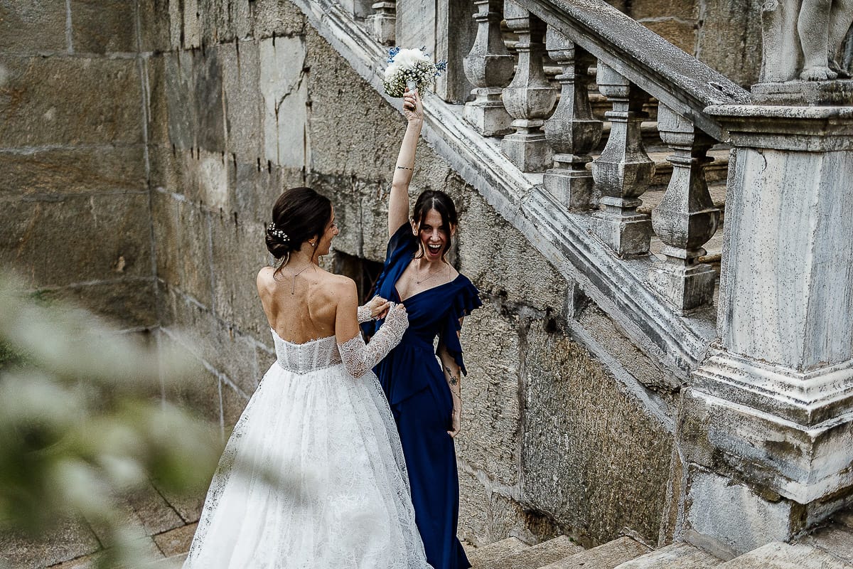 Matrimonio da favola al castello Canalis. Aperitivo. Lancio del bouquet. sposa abbraccia la ragazza che ha preso il bouquet.