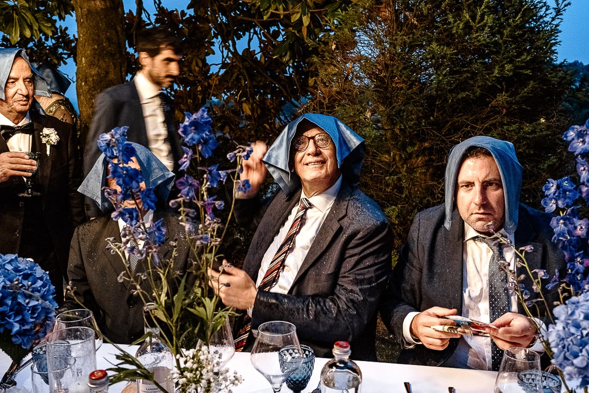 Matrimonio da favola al castello Canalis. Ricevimento. cena. Inizia a piovere. invitati si riparano con i tovaglioli posti sul capo.