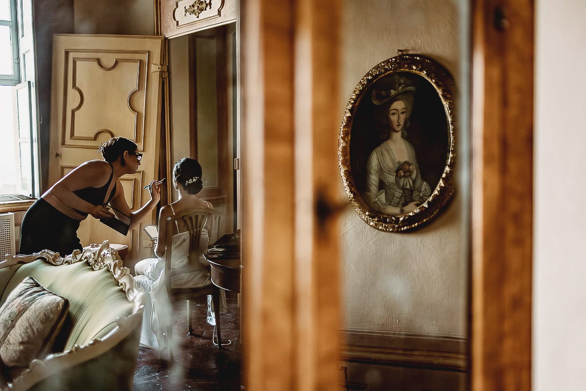 Matrimonio da favola al castello Canalis. Preparazione della sposa. Make-up- sposa riflessa nello specchio di un antico trumeau