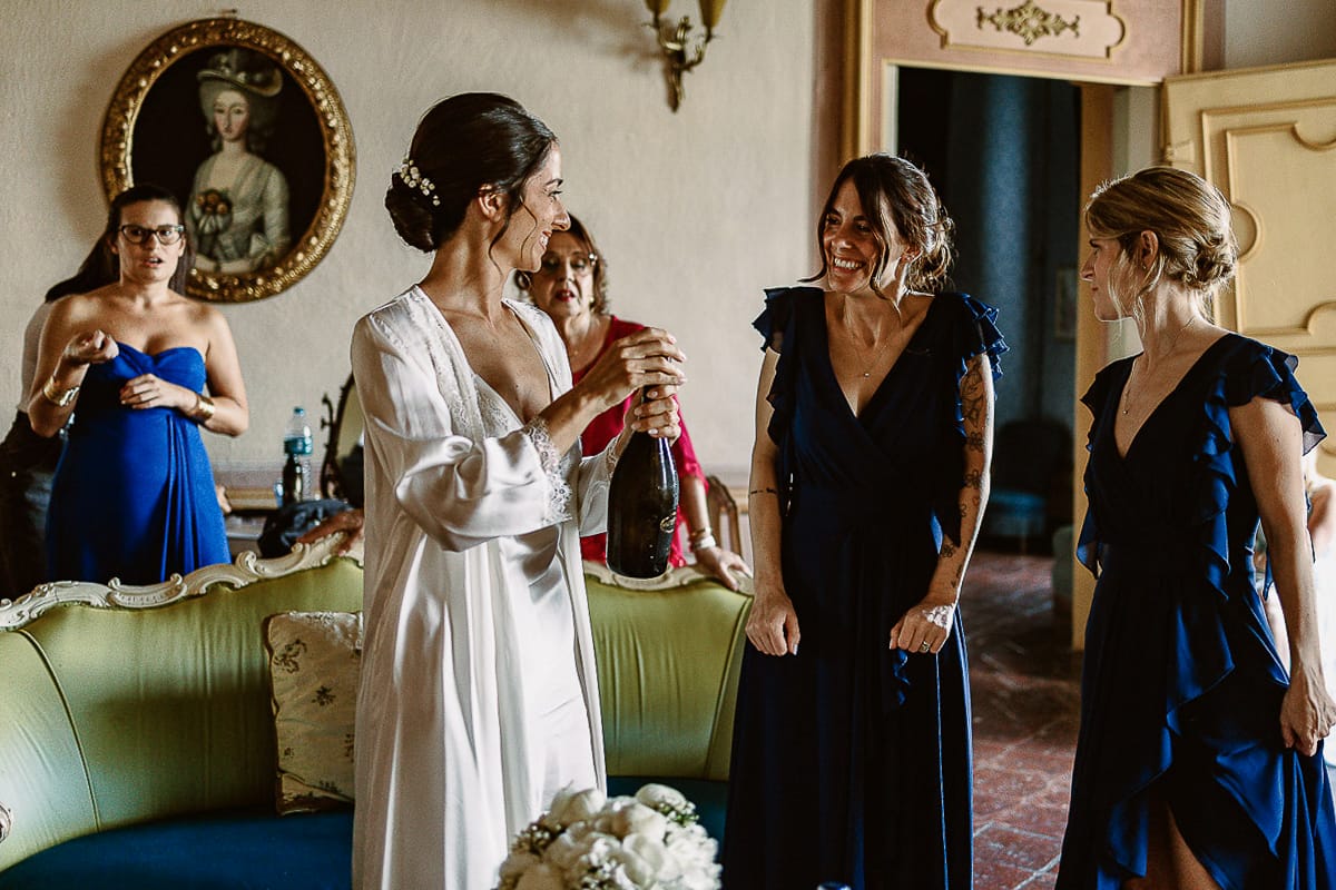 Matrimonio da favola al castello Canalis. Preparazione della sposa. Brindisi. la sposa si appresta a stappare la bottiglia di spumante.
