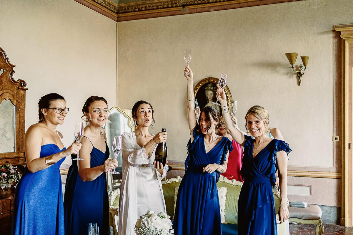 Matrimonio da favola al castello Canalis. Preparazione della sposa. La sposa stappa la bottiglia di spumante.