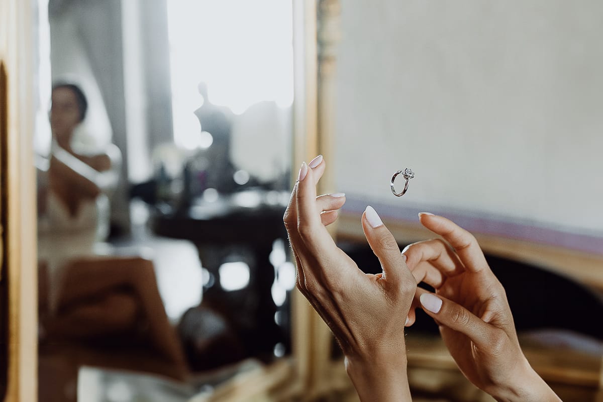 Matrimonio da favola al castello Canalis. Preparazione della sposa.Anello sospeso tra le mani della sposa