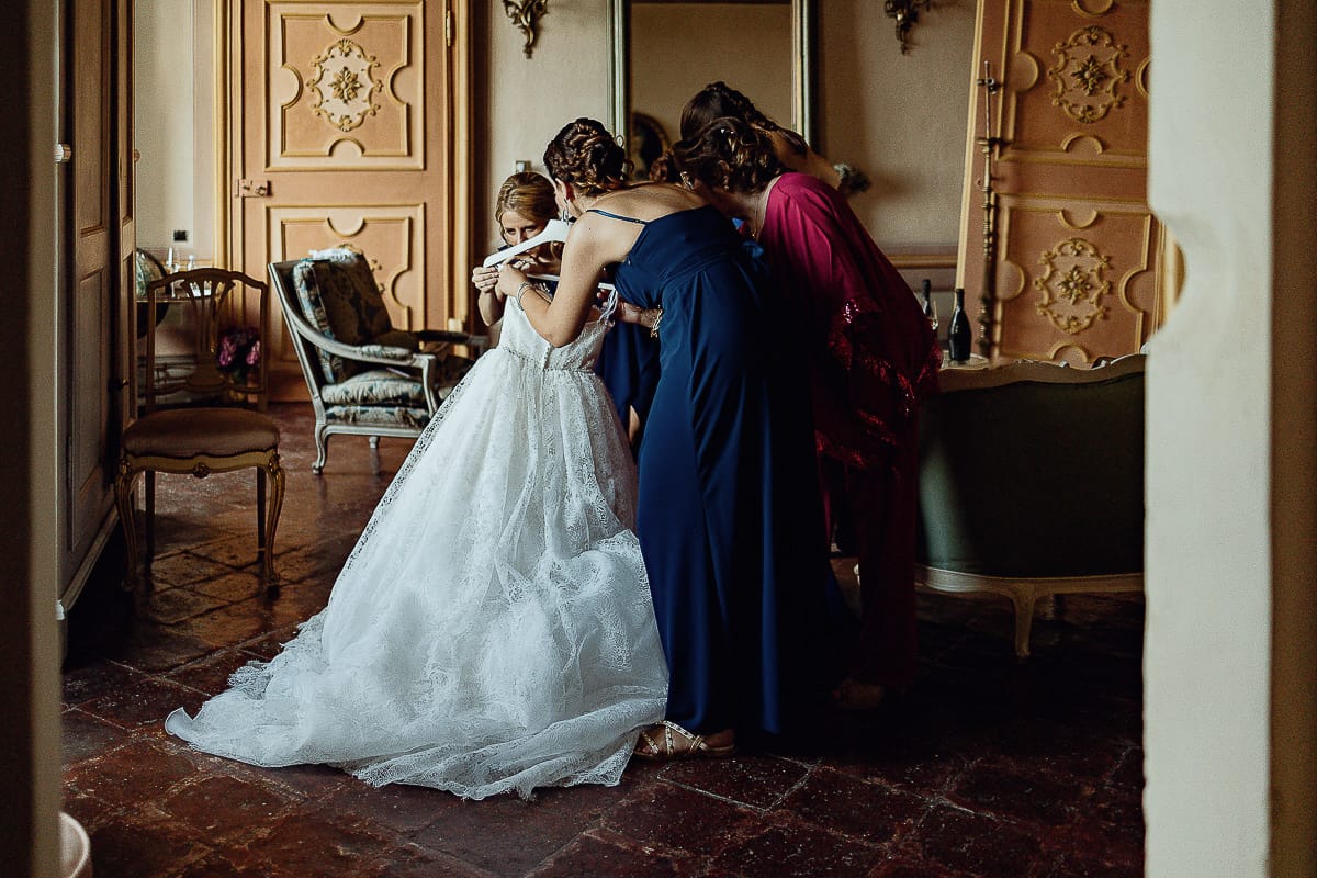 Matrimonio da favola al castello Canalis. Preparazione della sposa. Le damigelle preparano il vestito della sposa per farglielo indossare