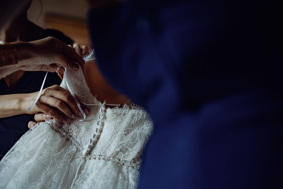 Matrimonio da favola al castello Canalis. Preparazione della sposa. Le damigelle preparano il vestito della sposa per farglielo indossare