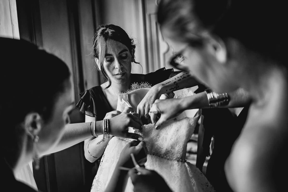 Matrimonio da favola al castello Canalis. Preparazione della sposa. Le damigelle preparano il vestito della sposa per farglielo indossare