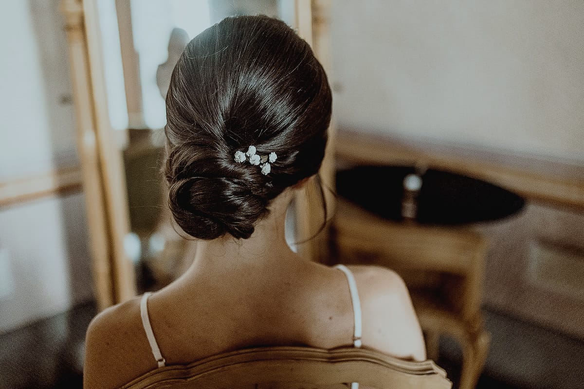 Matrimonio da favola al castello Canalis. Preparazione della sposa. Acconciatura della sposa.capelli raccolti in uno chignon basso con gypsophila