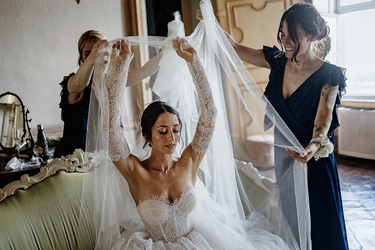 Matrimonio da favola al castello Canalis. Preparazione della sposa. Le damigelle mettono il velo alla sposa