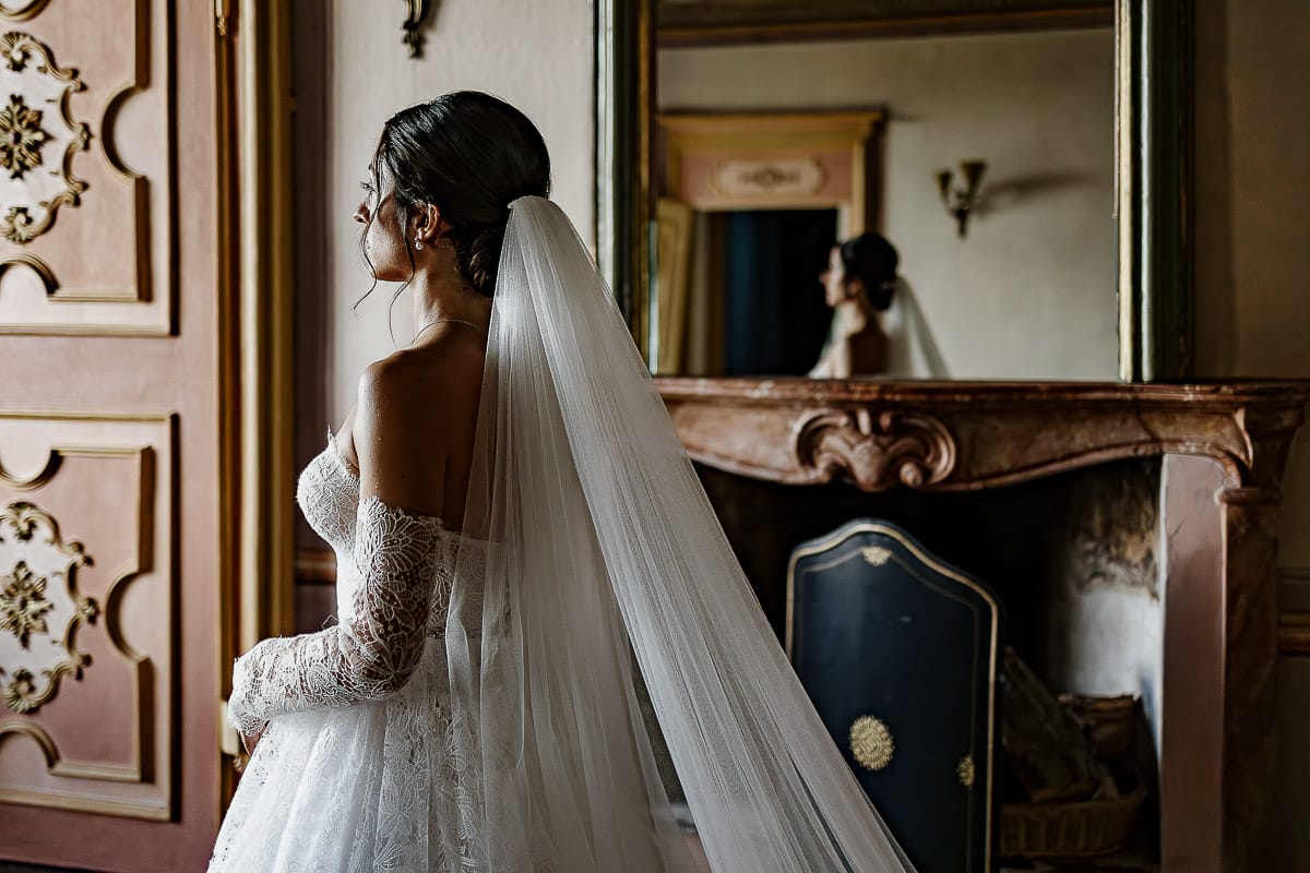 Matrimonio da favola al castello Canalis. Preparazione della sposa.Ritratto della sposa riflessa nella specchiera del camino.