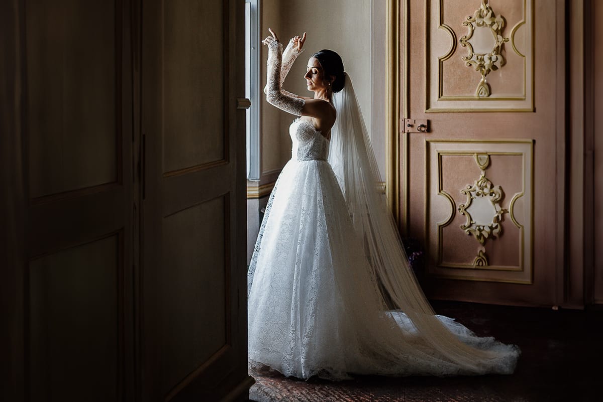 Matrimonio da favola al castello Canalis. Preparazione della sposa. Ritratto della sposa alla finestra.