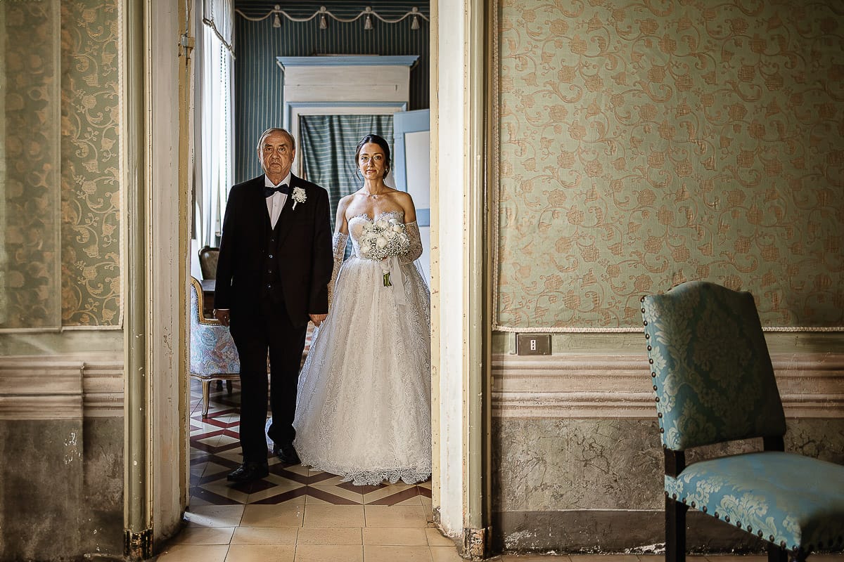 Matrimonio da favola al castello Canalis. Cerimonia. Sposa con ilpadre si appresta ad entrare nel salone per la cerimonia.