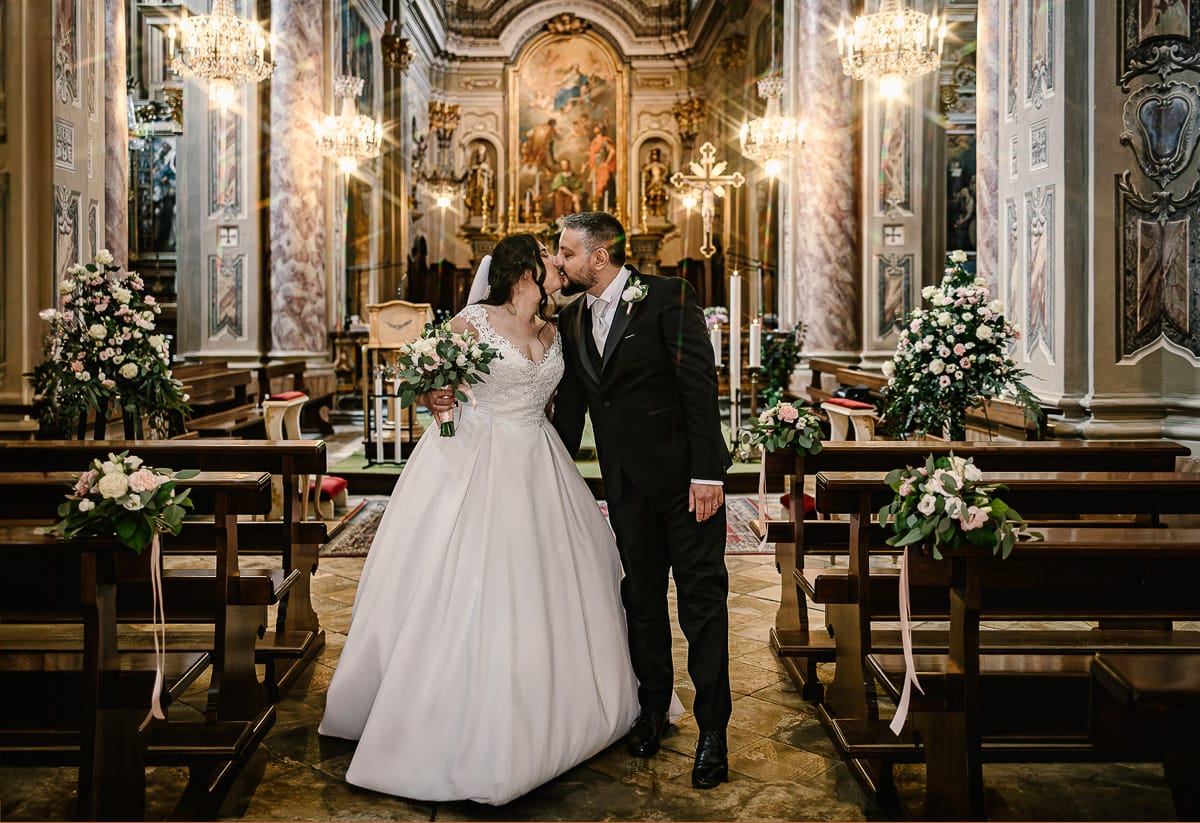 Matrimonio a Riva presso Chieri. Cerimonia. Uscita degli sposi con bacio.