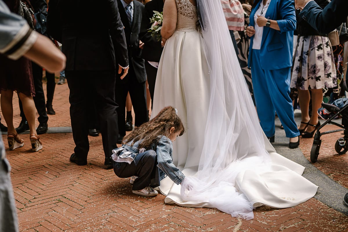 Matrimonio a Riva presso Chieri. Cerimonia. Lancio del riso. Bambina raccoglie il riso dallo strascico della sposa