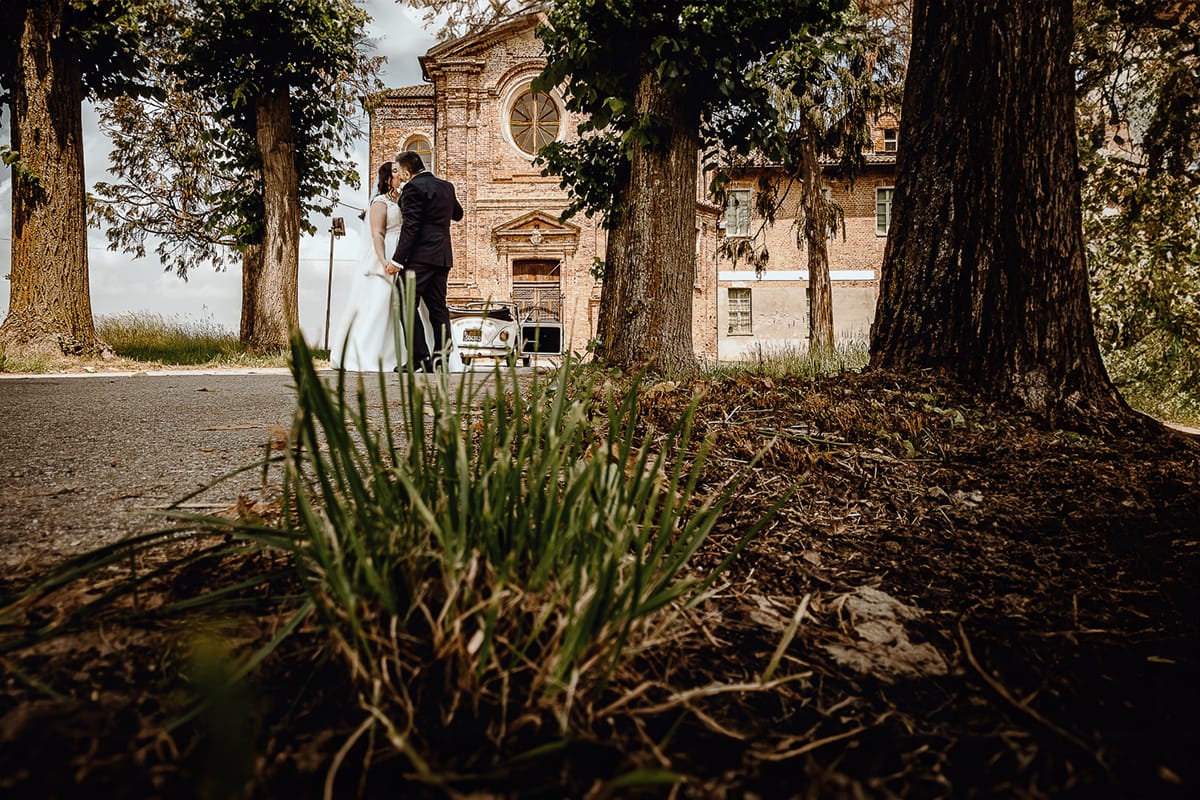 Matrimonio a Riva presso Chieri. Ritratti degli sposi. Sposi davanti all'auto, un maggiolino bianco d'epoca decappottabile