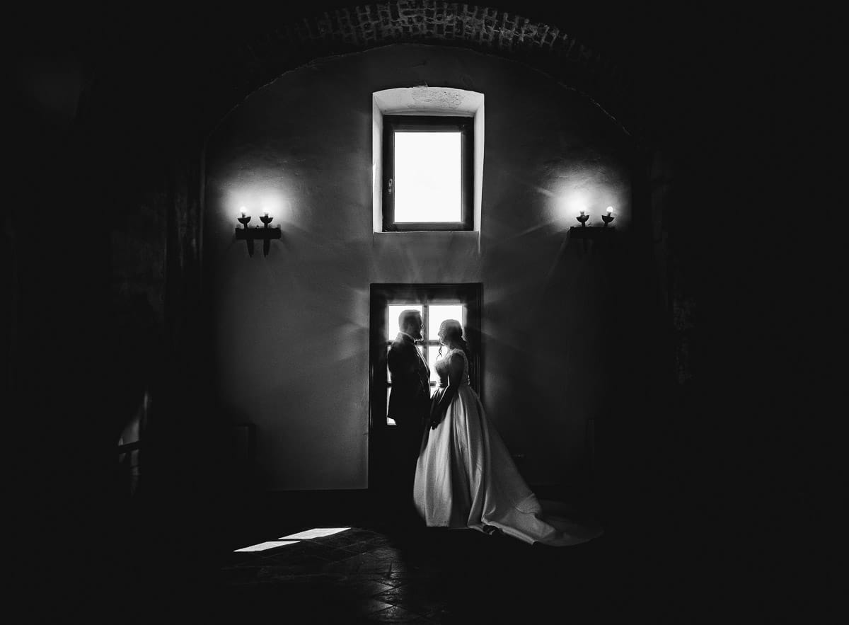Matrimonio al Castello di Cortanze. Ritratto degli sposi davanti ad una finestra in controluce