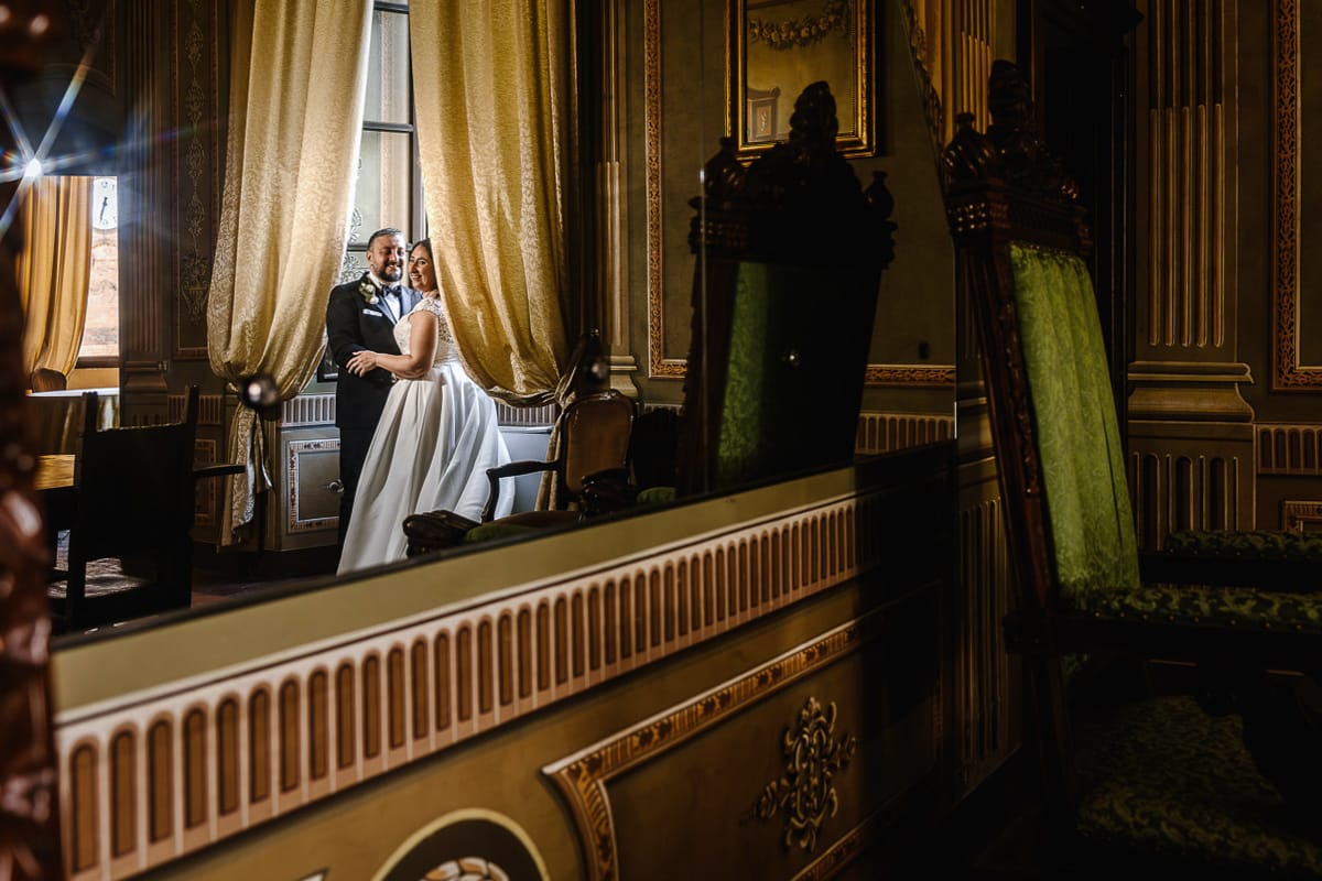Matrimonio al Castello di Cortanze. Ritratto degli sposi in una sala riflessi in una grande specchiera ottocentesca.