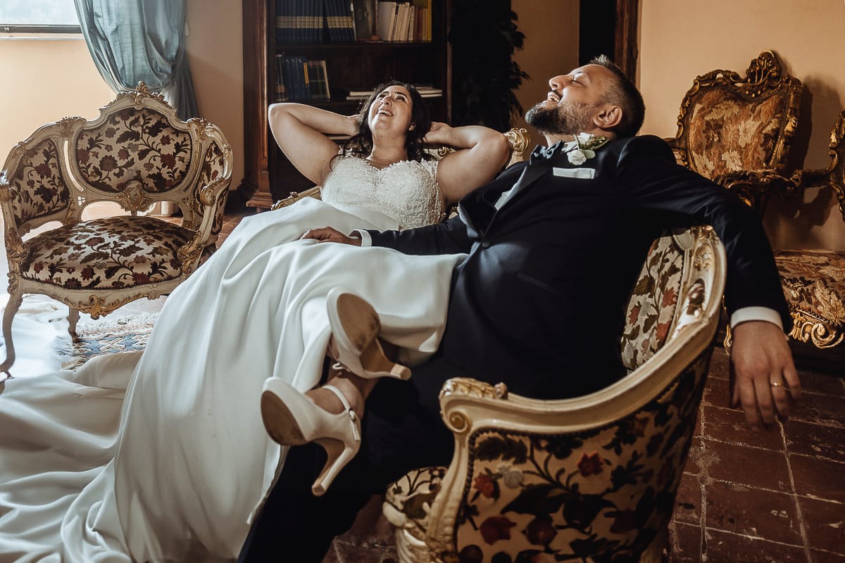 Matrimonio al Castello di Cortanze. Ritratto degli sposi rilassati su di un divano antico.