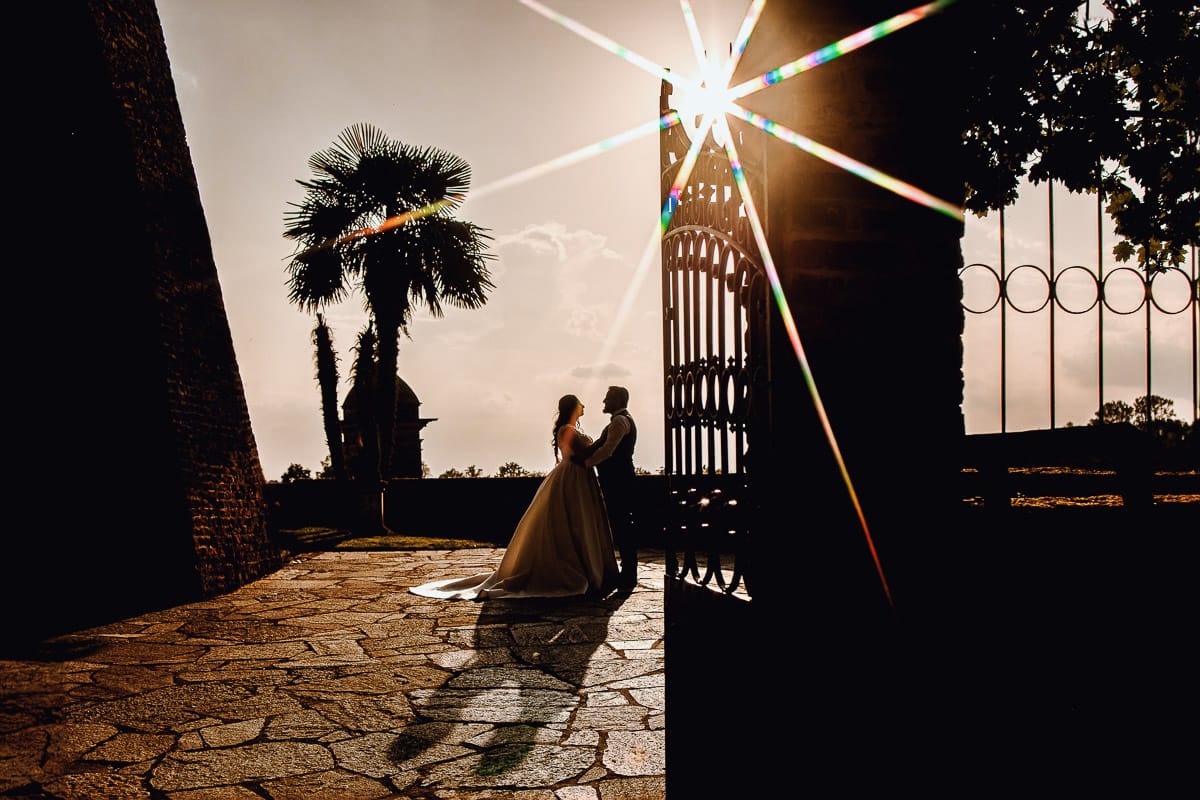 Matrimonio al Castello di Cortanze. Ritratto degli sposi in controluce al tramonto.