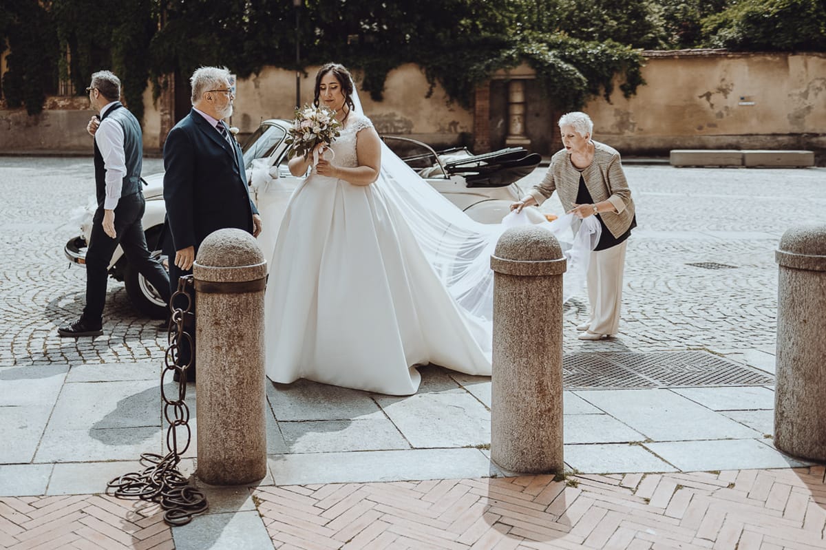 Matrimonio a Riva presso Chieri. Cerimonia. Sposa con il padre furi dall'auto. la madre le sistema il velo.