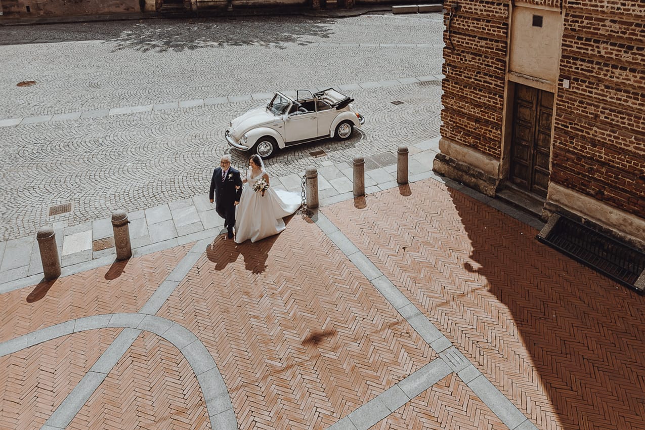 Matrimonio a Riva presso Chieri. Cerimonia. Sposa con il padre fuori dall'auto. Foto ripresa dal drone.