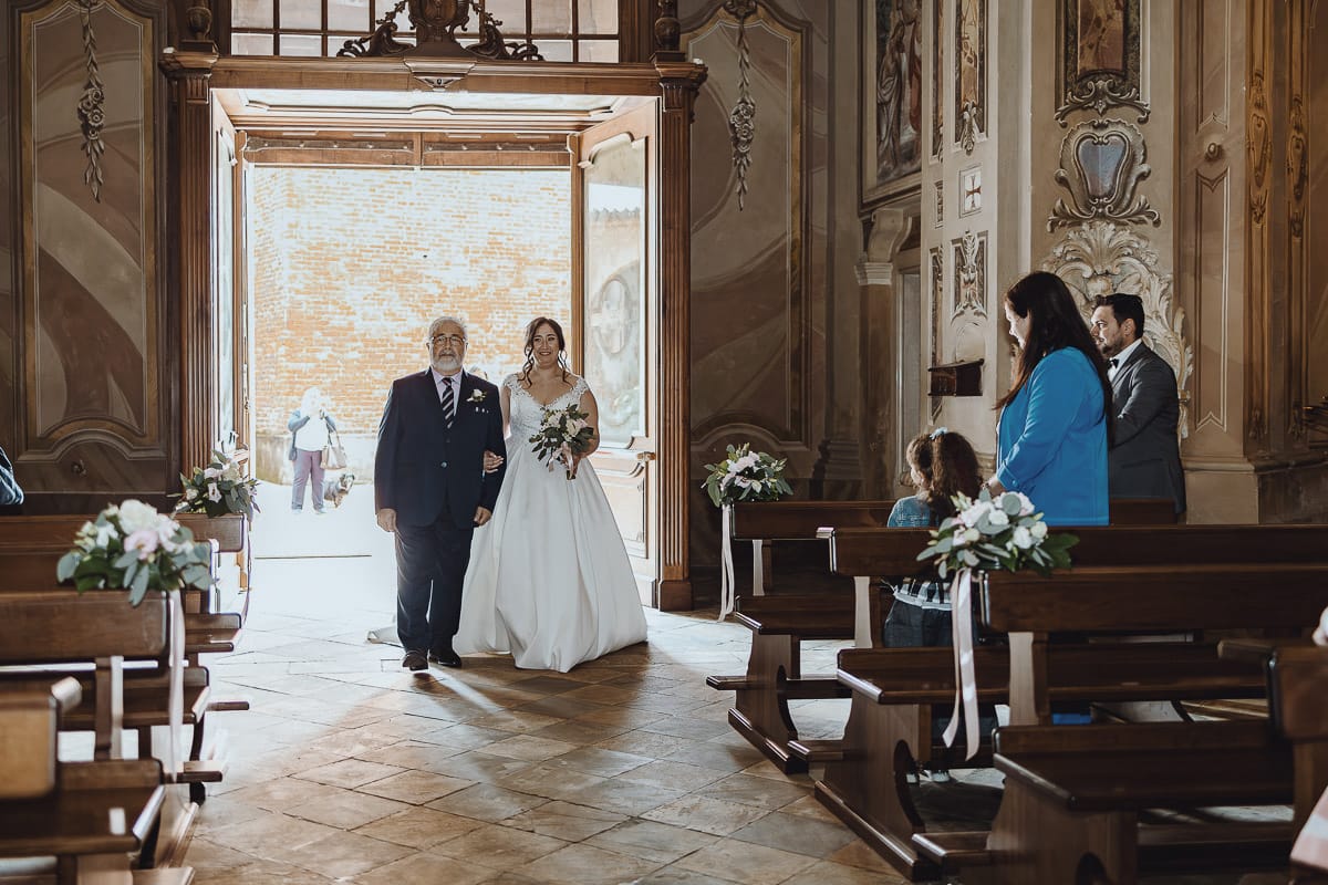 Matrimonio a Riva presso Chieri. Cerimonia. Sposa entra in chiesa al braccio del padre