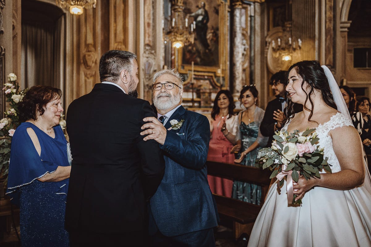 Matrimonio a Riva presso Chieri. Cerimonia. Padre della sposa abbraccia lo sposo