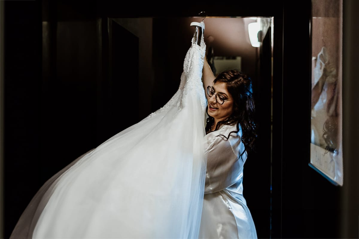 Matrimonio a San Mauro Torinese. Preparazione della sposa. Sposa prende l'abito