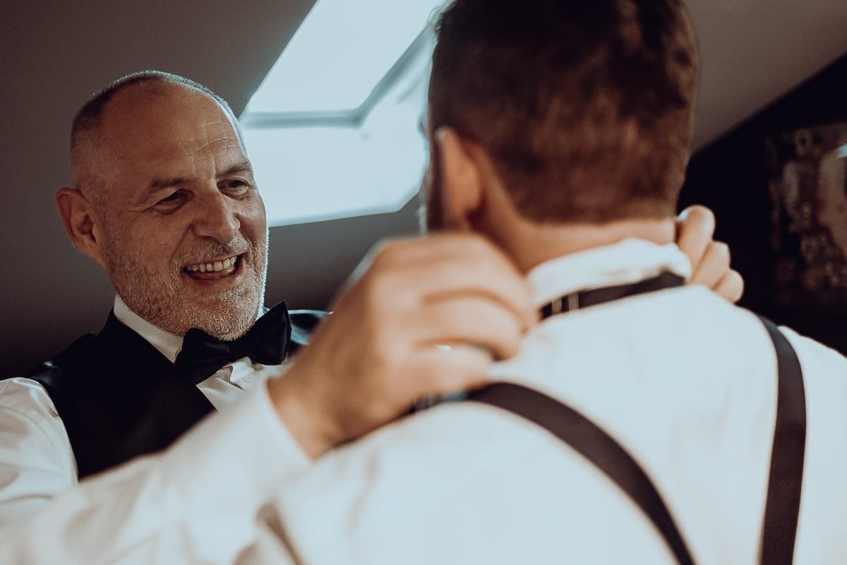 Matrimonio a San Mauro Torinese. Preparazione della sposa. Papà aiuta il figlio, fratello della sposa, nella vestizione