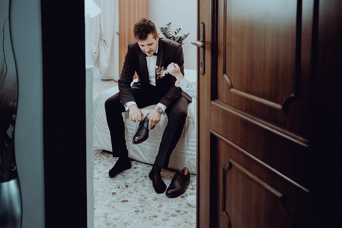 Matrimonio a San Mauro Torinese. Preparazione dello sposo.Sposo si mette le scarpe