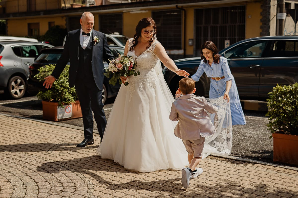 Matrimonio a San Mauro Torinese. Cerimonia. La sposa scende dall'auto. La wp le sistema il velo.