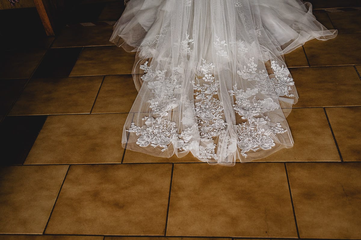 Matrimonio a San Mauro Torinese. Cerimonia. Sposa entra in chiesa. Dettaglio dello strascico