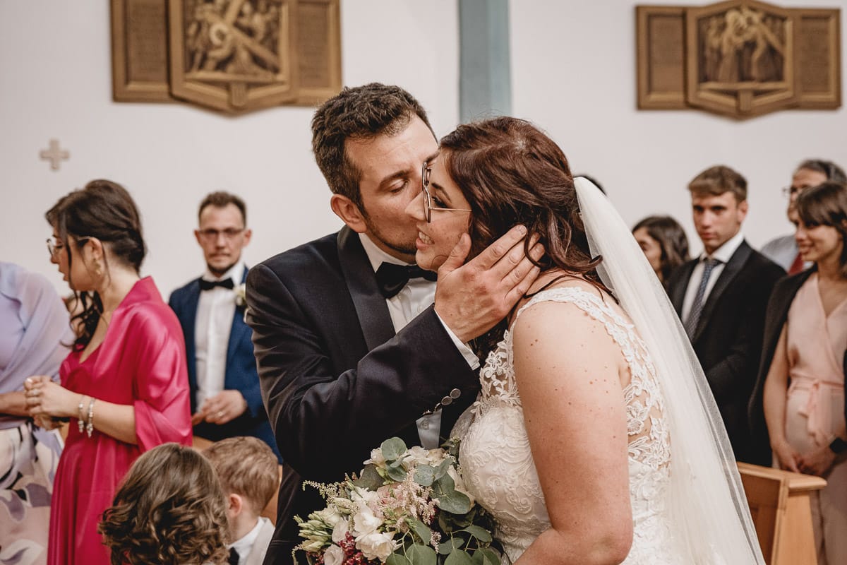 Matrimonio a San Mauro Torinese. Cerimonia. Sposo bacia la sposa sulla guancia