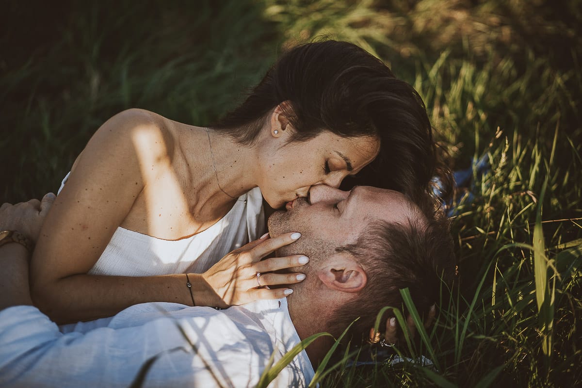 Prewedding romantico e da sogno al tramonto in Monferrato. Valeria e Omar sdraiati fra l'erba si baciano