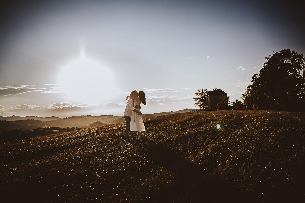 Prewedding romantico e da sogno al tramonto in Monferrato. Valeria e Omar si abbracciano in un campo di grano tagliato.