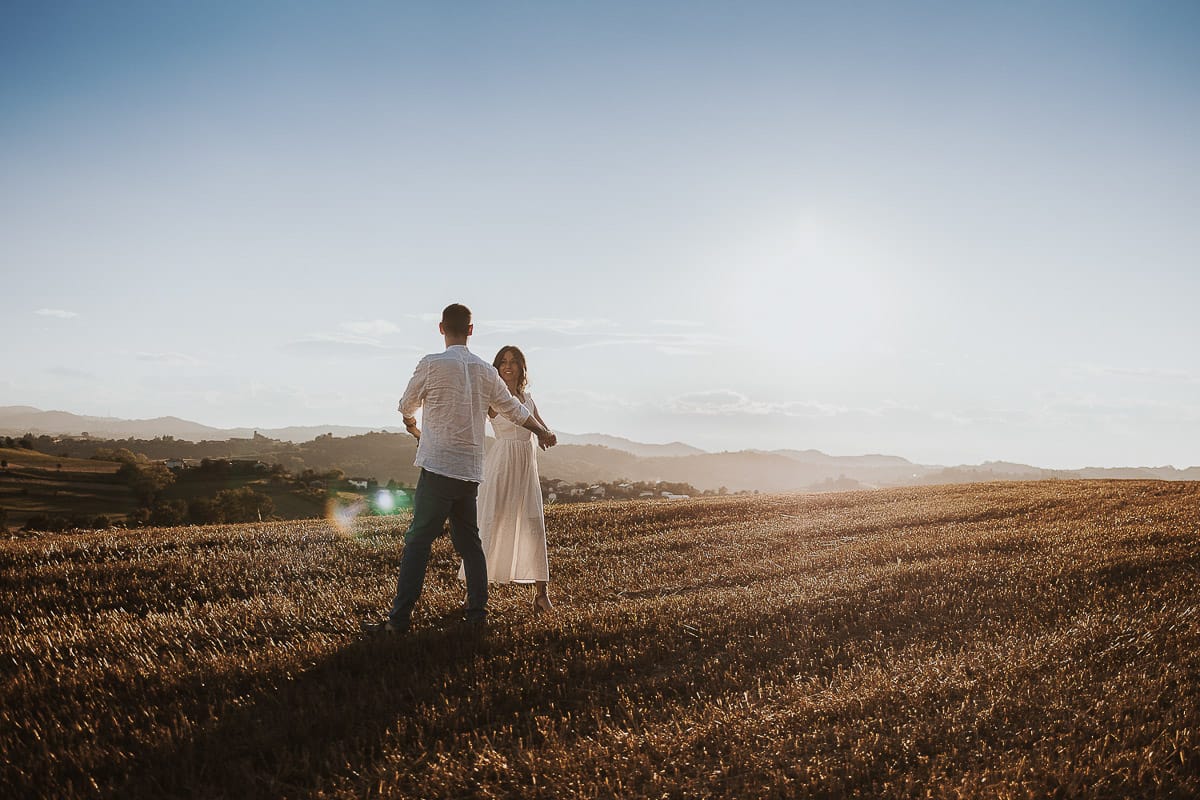 Prewedding romantico e da sogno al tramonto in Monferrato. Valeria e Omar danzano in un campo di grano tagliato.