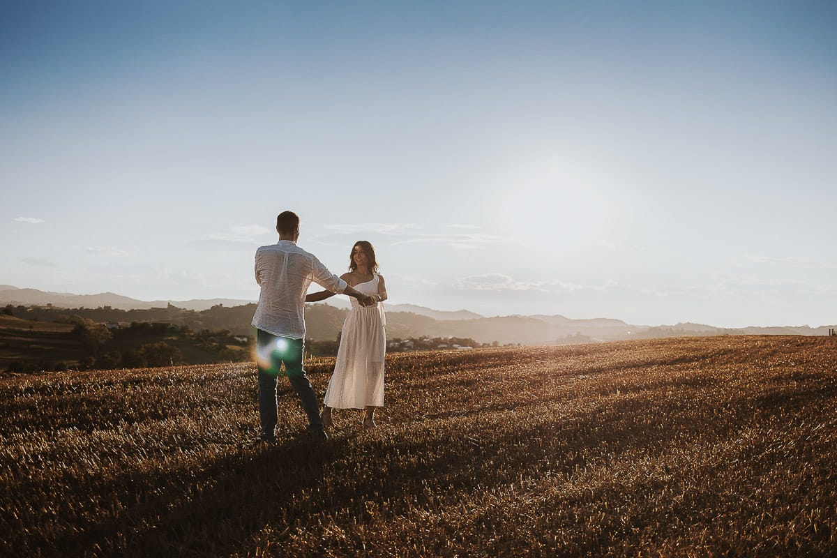 Prewedding romantico e da sogno al tramonto in Monferrato. Valeria e Omar danzano in un campo di grano tagliato.