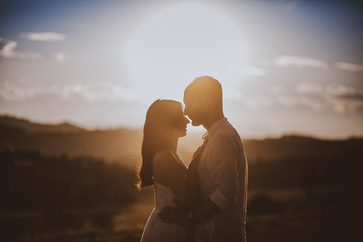 Prewedding romantico e da sogno al tramonto in Monferrato. Valeria e Omar si guardano. Ritratto in controluce.