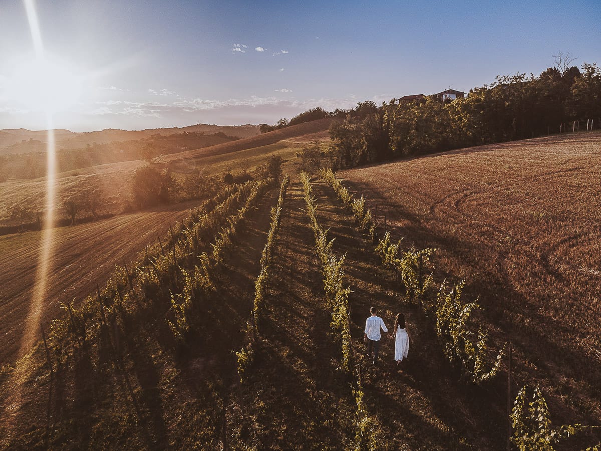Prewedding romantico e da sogno al tramonto in Monferrato. Valeria e Omar camminano nel vigneto ripresa aerea dal drone