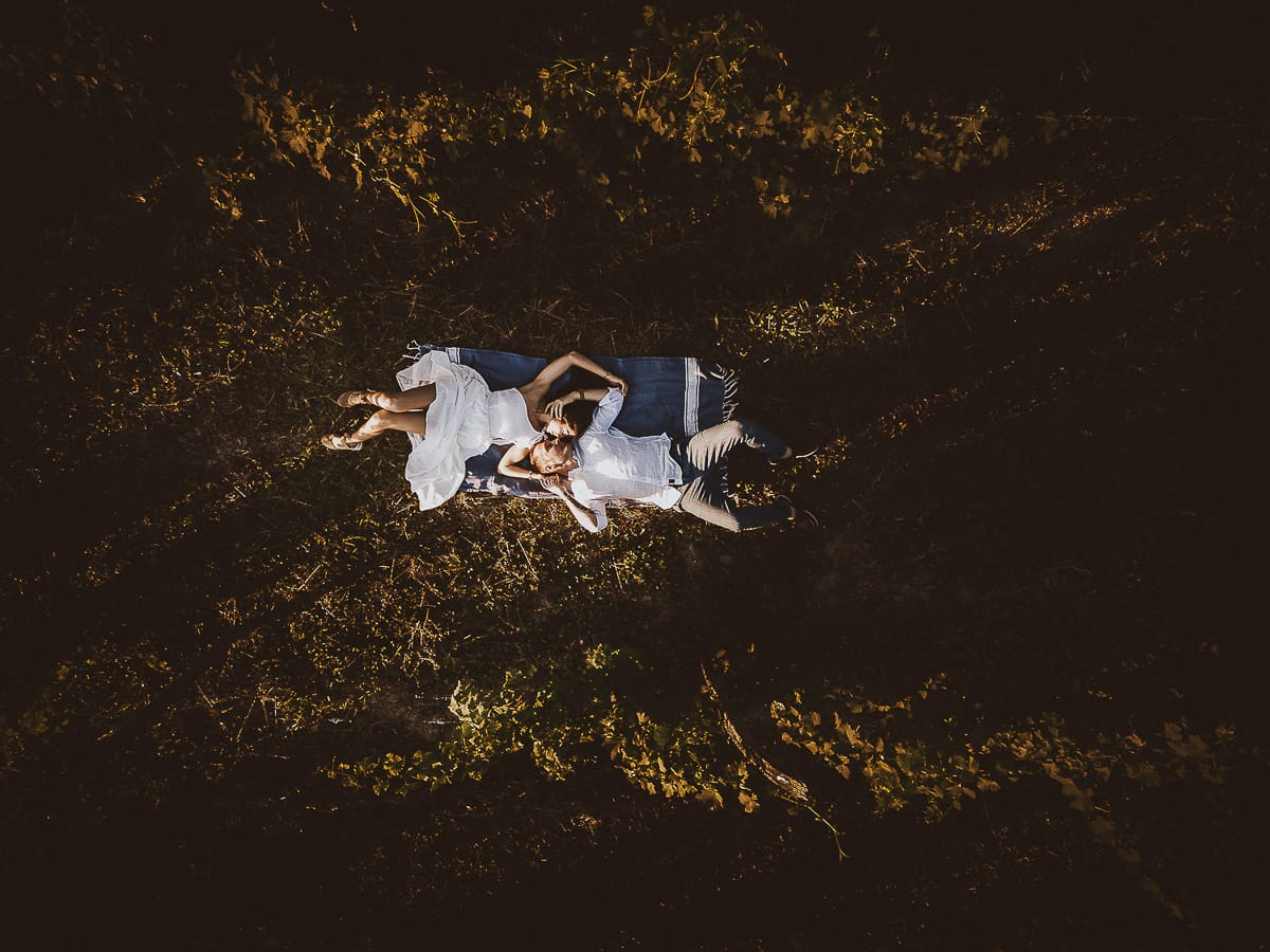 Prewedding romantico e da sogno al tramonto in Monferrato. Valeria e Omar sdraiati nel vigneto. Foto dal drone
