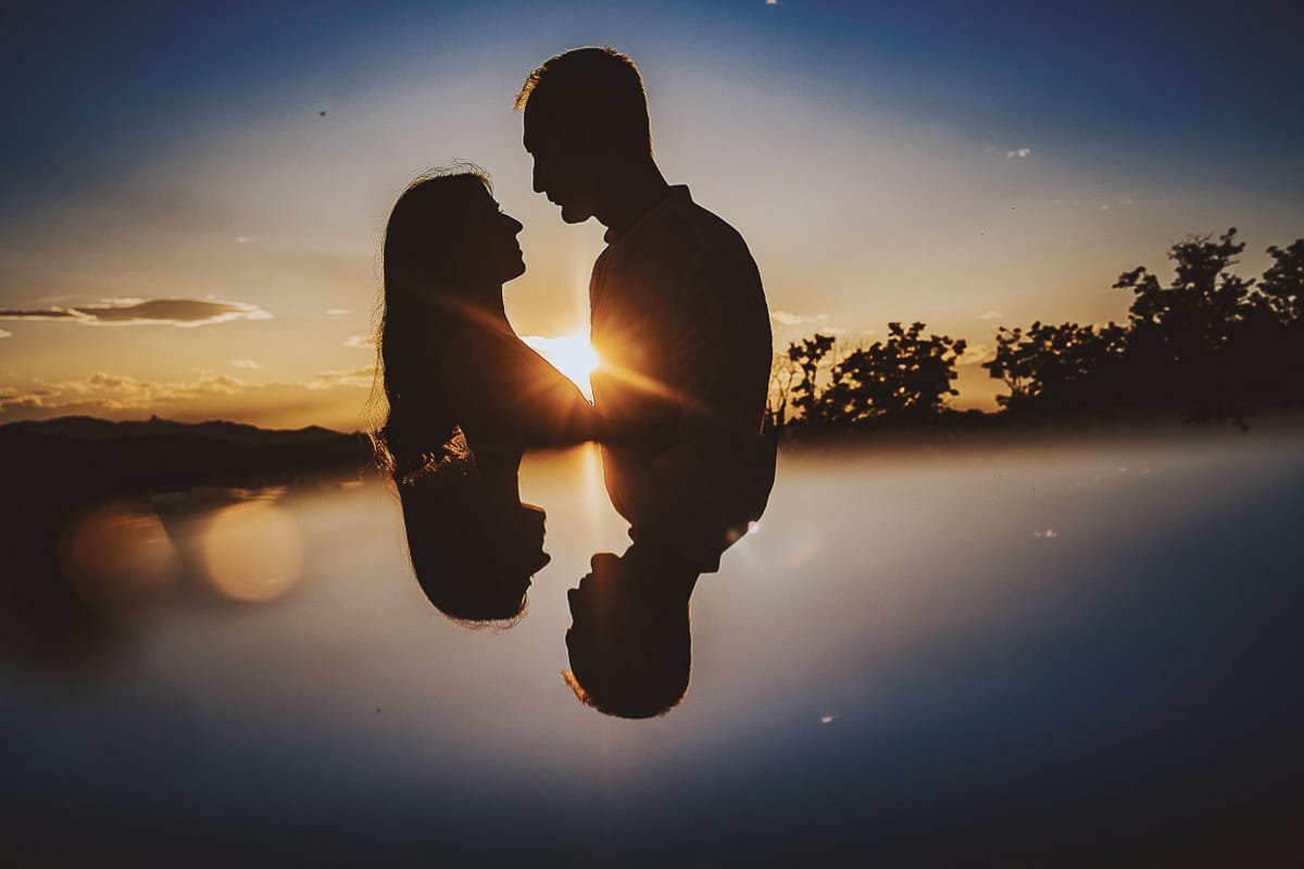 Prewedding romantico e da sogno al tramonto in Monferrato. Silhouette di Valeria e Omar con il sole che tramonta fra di loro e crea una stella di flare. Riflessione con uno specchio.