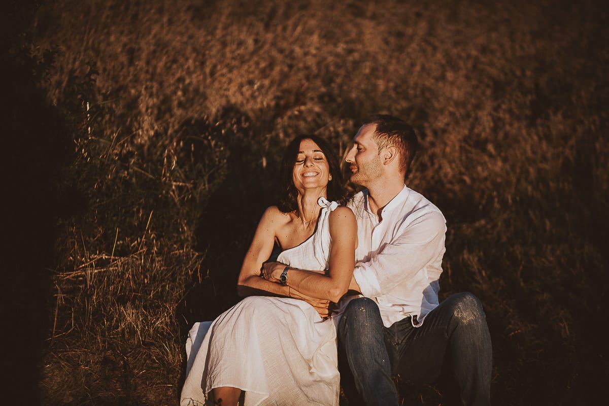 Prewedding romantico e da sogno al tramonto in Monferrato. Valeria e Omar seduti al bordo di un campo di grano.