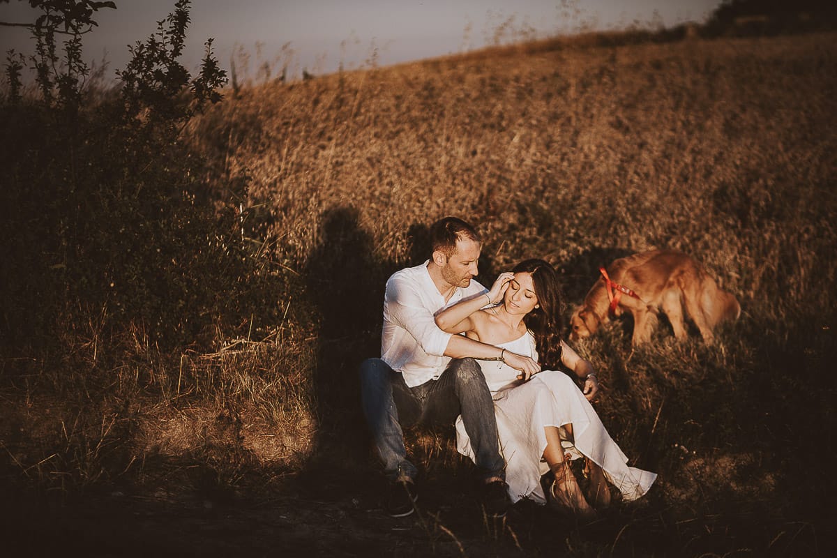 Prewedding romantico e da sogno al tramonto in Monferrato. Valeria e Omar seduti al bordo di un campo di grano.