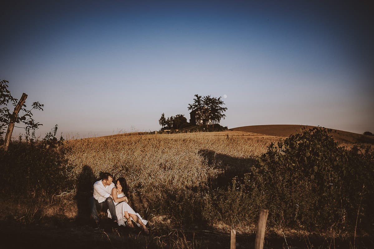 Prewedding romantico e da sogno al tramonto in Monferrato. Valeria e Omar seduti al bordo di un campo di grano.