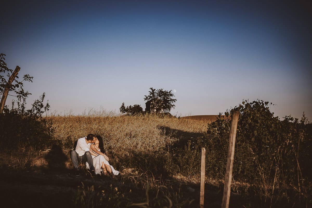 Prewedding romantico e da sogno al tramonto in Monferrato. Valeria e Omar seduti al bordo di un campo di grano.