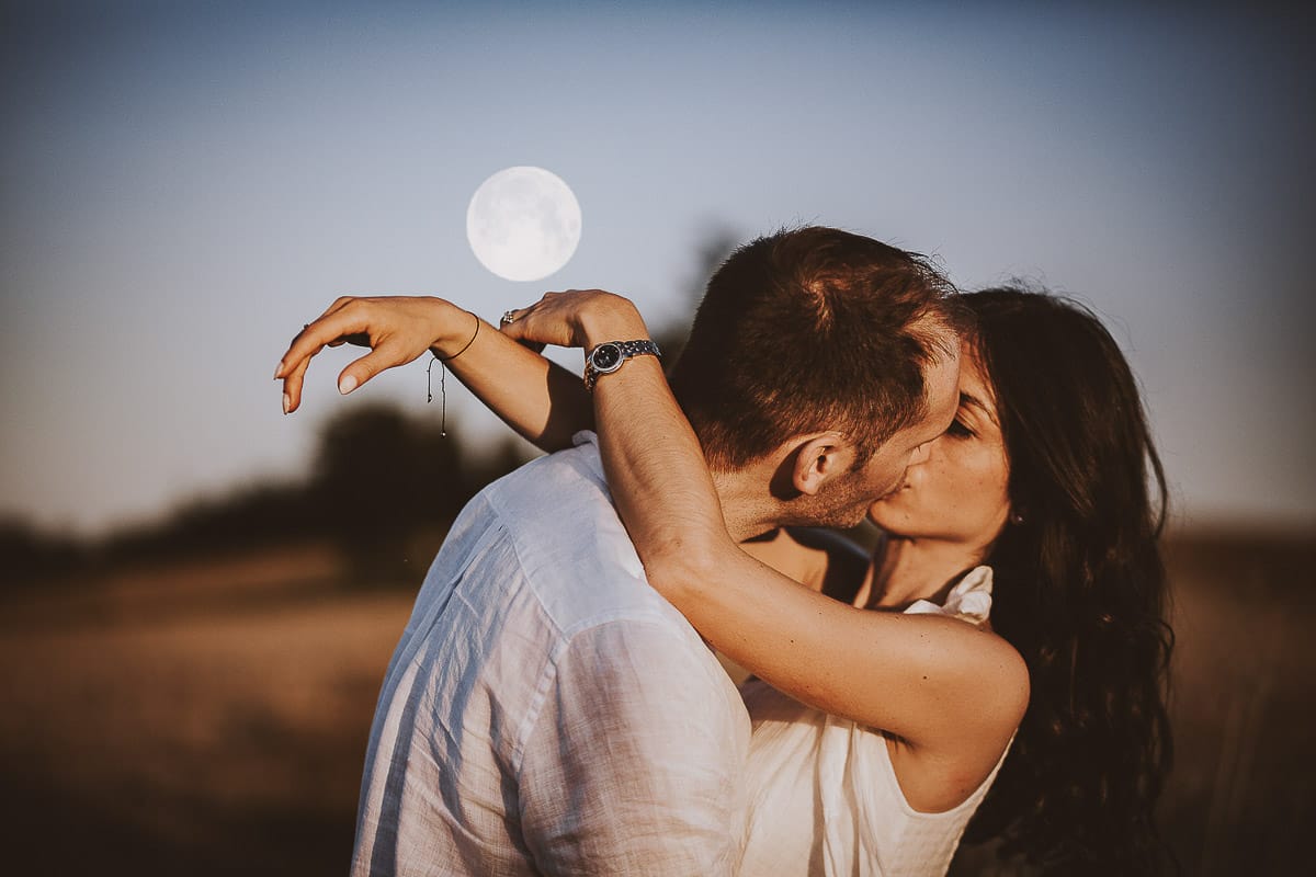 Prewedding romantico e da sogno al tramonto in Monferrato. Ritratto ravvicinato di Valeria e Omar che si baciano con la luna piena.