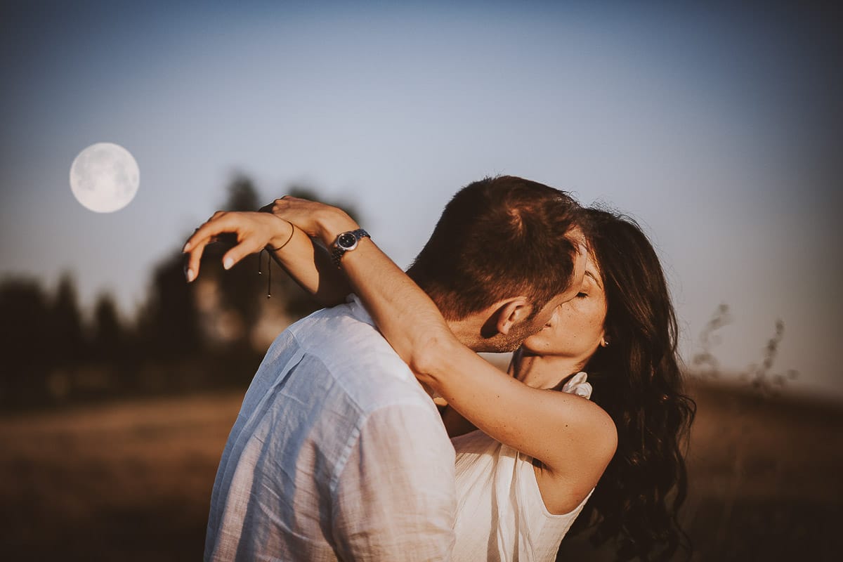 Prewedding romantico e da sogno al tramonto in Monferrato. Ritratto ravvicinato di Valeria e Omar che si baciano con la luna piena.